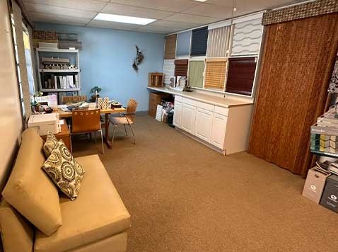 Showroom featuring various textiles, an accent chair, and meeting desk.